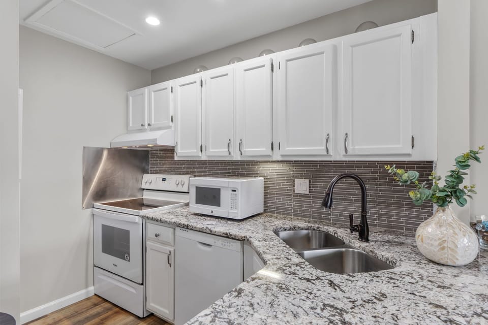 Prepare your favorite meals in this fully-equipped kitchen with granite countertops, stainless appliances, and elegant tile backsplash.