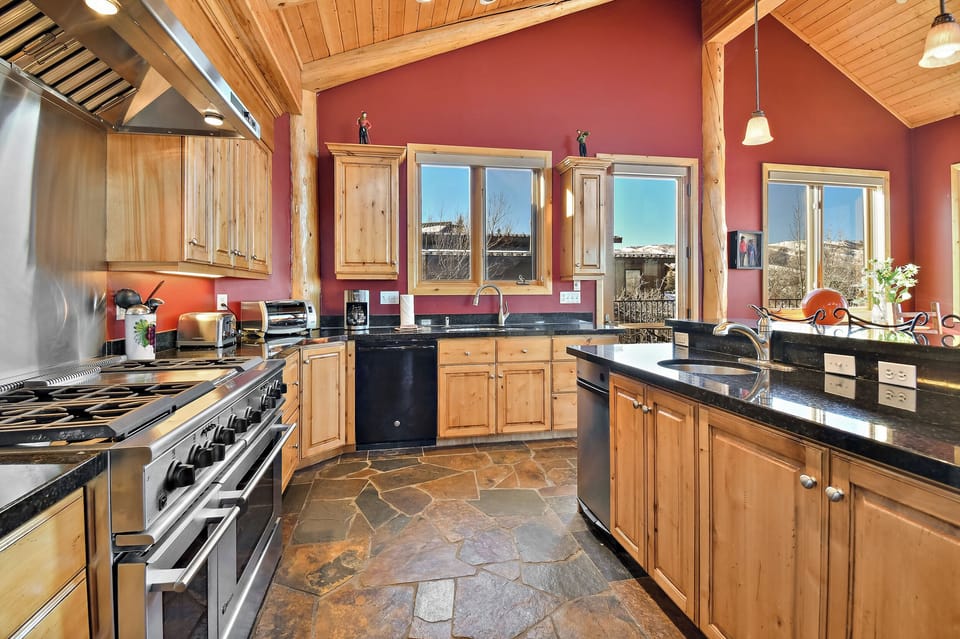 Cook memorable meals in this stunning kitchen featuring natural wood cabinets, granite countertops, and mountain views through every window.