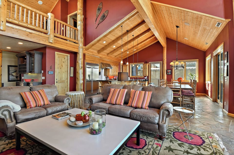 Relax in this stunning open-concept living space with vaulted ceilings, leather seating, and mountain cabin charm.