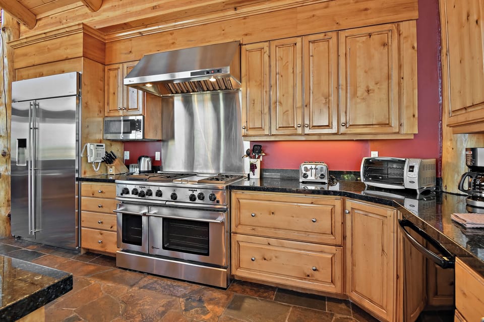 Whip up memorable meals in this gourmet kitchen featuring warm wood cabinetry, granite counters, and professional-grade appliances.