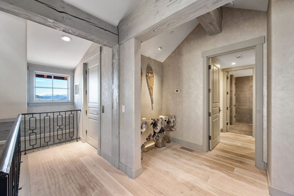 Discover your elegant retreat where rustic beams meet modern comfort in this sophisticated hallway with stunning mountain views.
