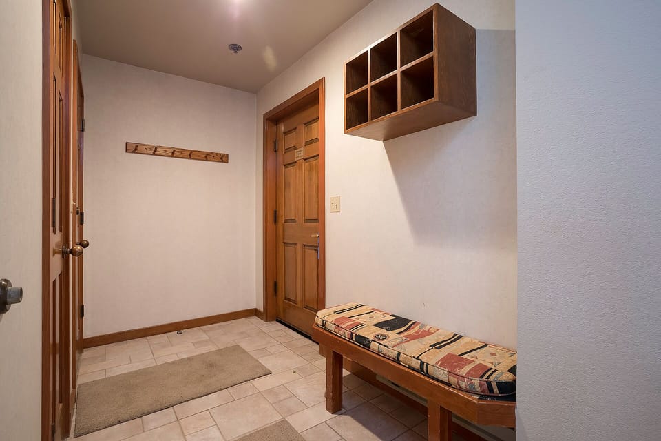 Your private mudroom welcomes you with warm wood storage cubbies and a cozy bench to settle in after mountain adventures.