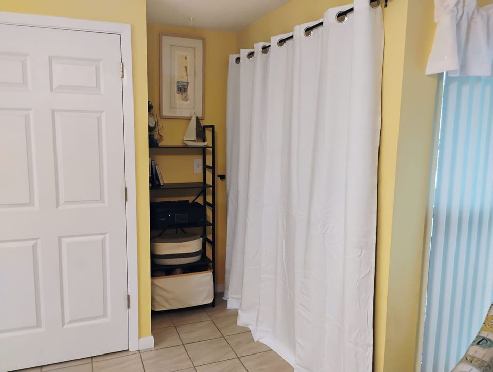 Your bright coastal studio features clever storage solutions with curtains creating private nooks for your belongings.