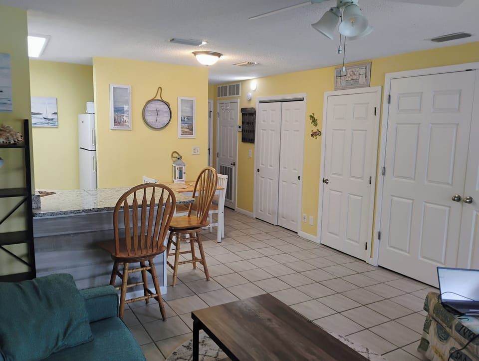 Settle into your cheerful open-plan space with sunny yellow walls, where the kitchen flows seamlessly into your dining and living area.