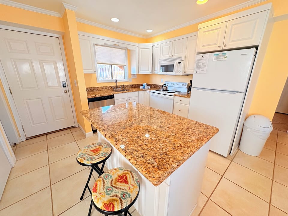 Your fully equipped kitchen features granite countertops, modern appliances, and a convenient breakfast bar for morning coffee or meal prep.