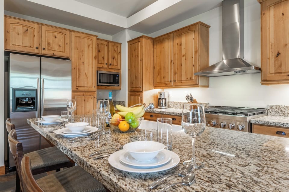 Picture yourself preparing meals in this fully equipped kitchen, featuring granite countertops, stainless steel appliances, and warm wood cabinetry—perfect for gathering and creating lasting memories together.