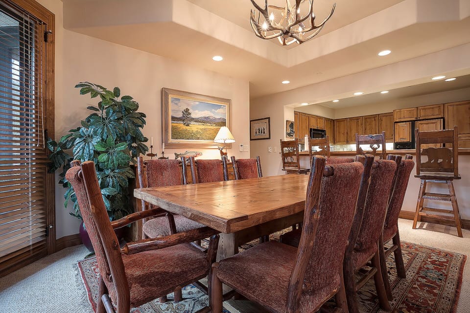 Gather around this rustic dining table for memorable meals with your group, featuring rich wood finishes and mountain lodge charm.