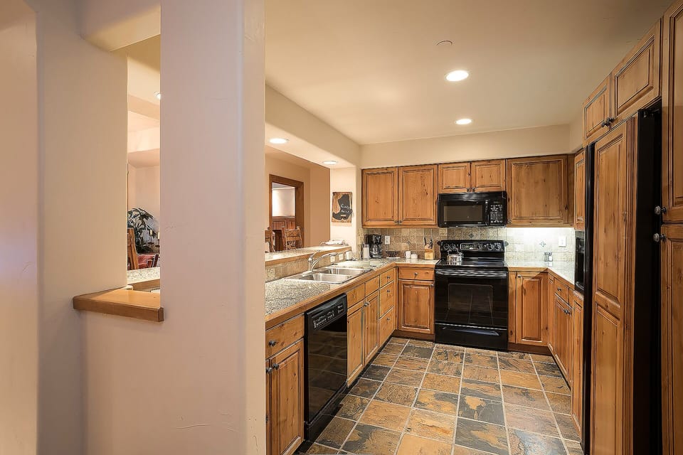 You'll love cooking in this spacious kitchen with warm wood cabinets, granite counters, and modern appliances.