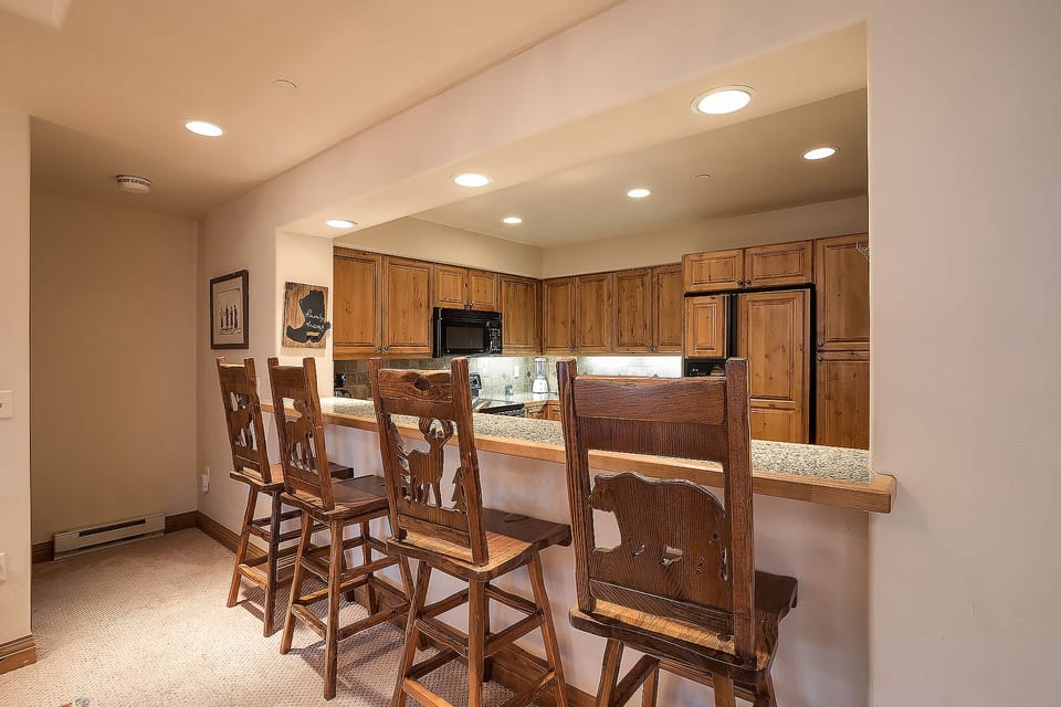 Your spacious kitchen features warm wood cabinetry, granite countertops, and a breakfast bar where you can enjoy morning coffee together.