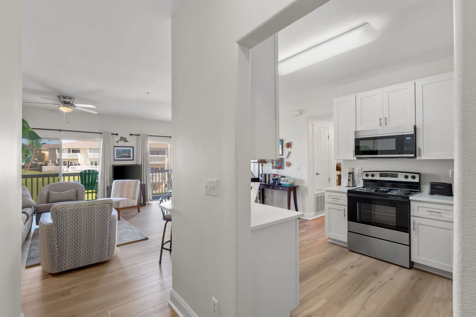 Your open-concept space flows seamlessly from kitchen to living area, with gleaming appliances and a bright balcony view.