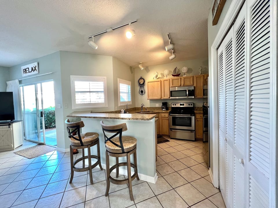 Your open kitchen features granite countertops, stainless appliances, and a breakfast bar where you can enjoy morning coffee with natural light streaming in.
