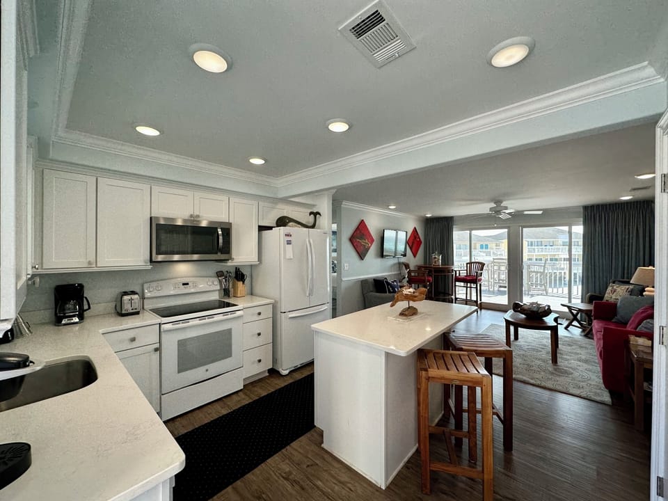 Your open kitchen flows seamlessly into the living area, featuring modern appliances and breakfast bar seating.