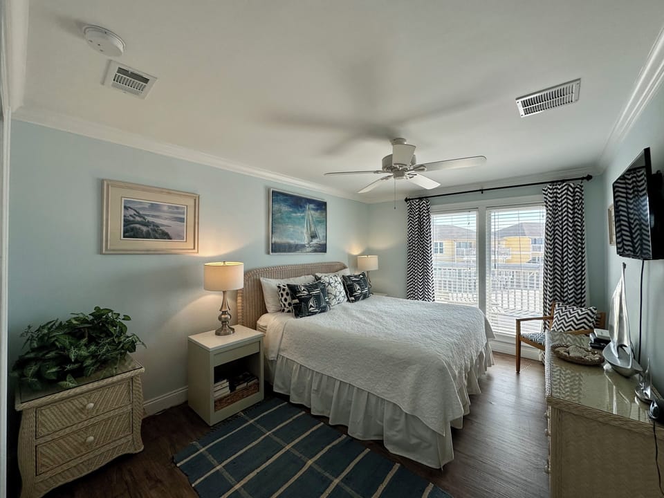 Sink into this serene coastal bedroom where nautical artwork and gentle blues create your peaceful retreat for restful nights.