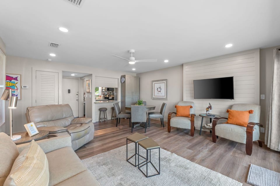 Relax in your spacious open-concept living area, where modern comfort meets coastal charm. Sink into plush seating, gather around the dining table, and unwind with entertainment—your home away from home.
