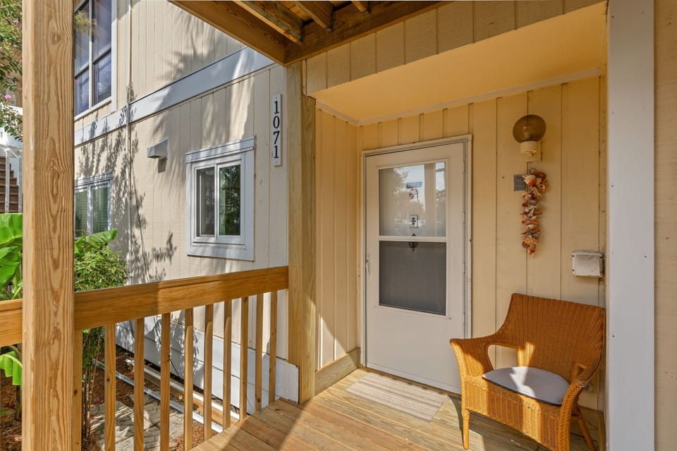 A charming covered entrance welcomes guests to unit 1071. The light-filled porch features warm wood tones and seasonal décor, creating an inviting arrival experience at this cozy retreat.