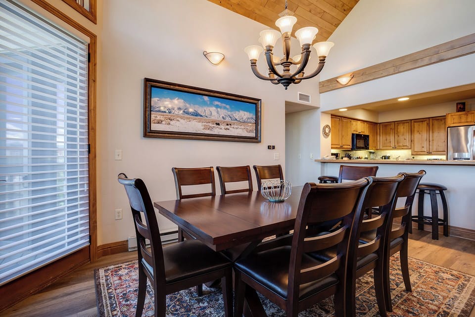 Gather around your elegant dining table for memorable meals, with warm lighting and mountain views creating the perfect atmosphere for family gatherings.