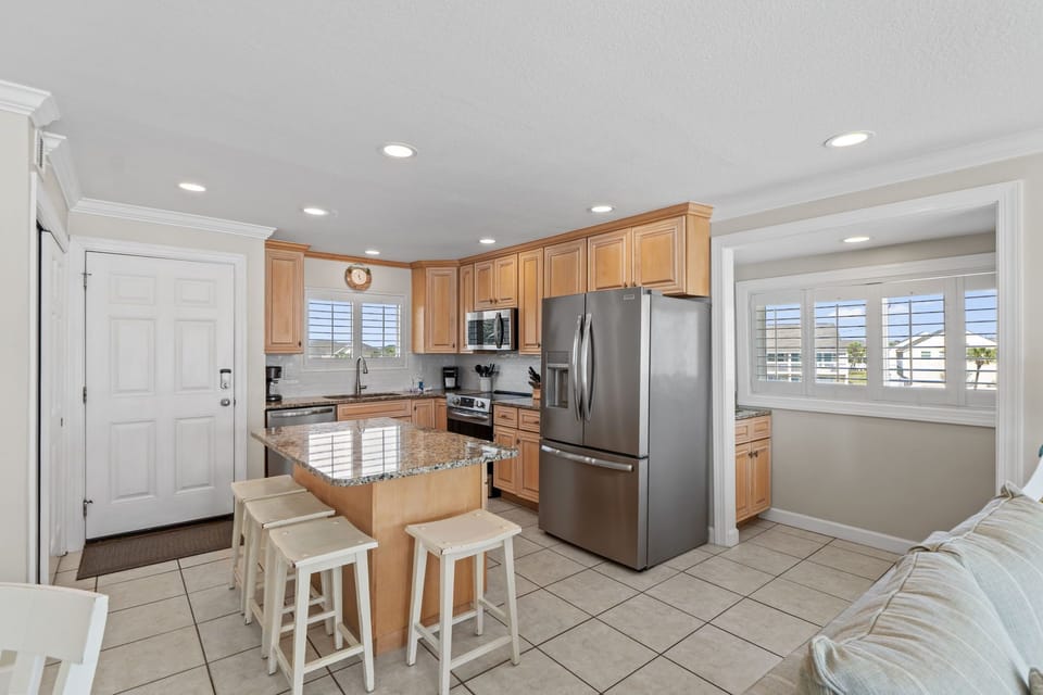 Your fully equipped kitchen awaits with granite counters, stainless appliances, and island seating for casual meals together.
