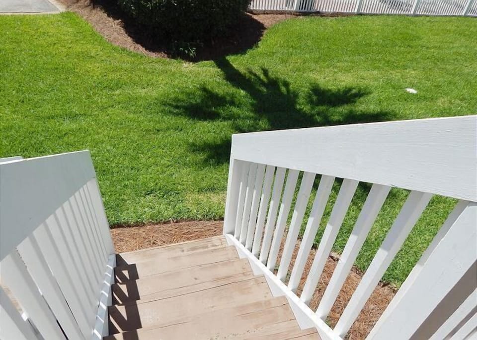 Step onto your private deck overlooking lush green lawn—perfect for morning coffee or evening relaxation in this peaceful outdoor retreat.