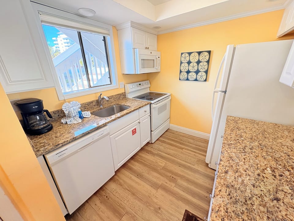 Your fully equipped kitchen features granite countertops, modern appliances, and sunny views—perfect for preparing meals during your stay.