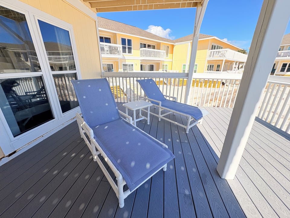Soak up the sunshine on your private covered balcony with comfortable lounge chairs—perfect for morning coffee or afternoon relaxation.