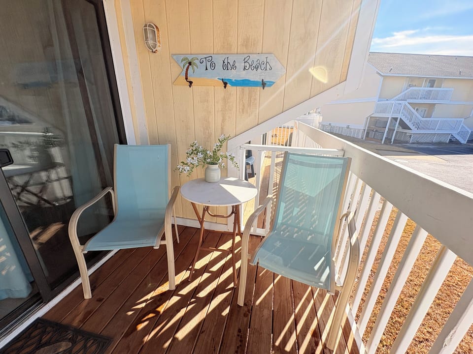 Sip your morning coffee on this charming beach-themed balcony, complete with cozy seating and delightful coastal decor that sets the perfect vacation mood.