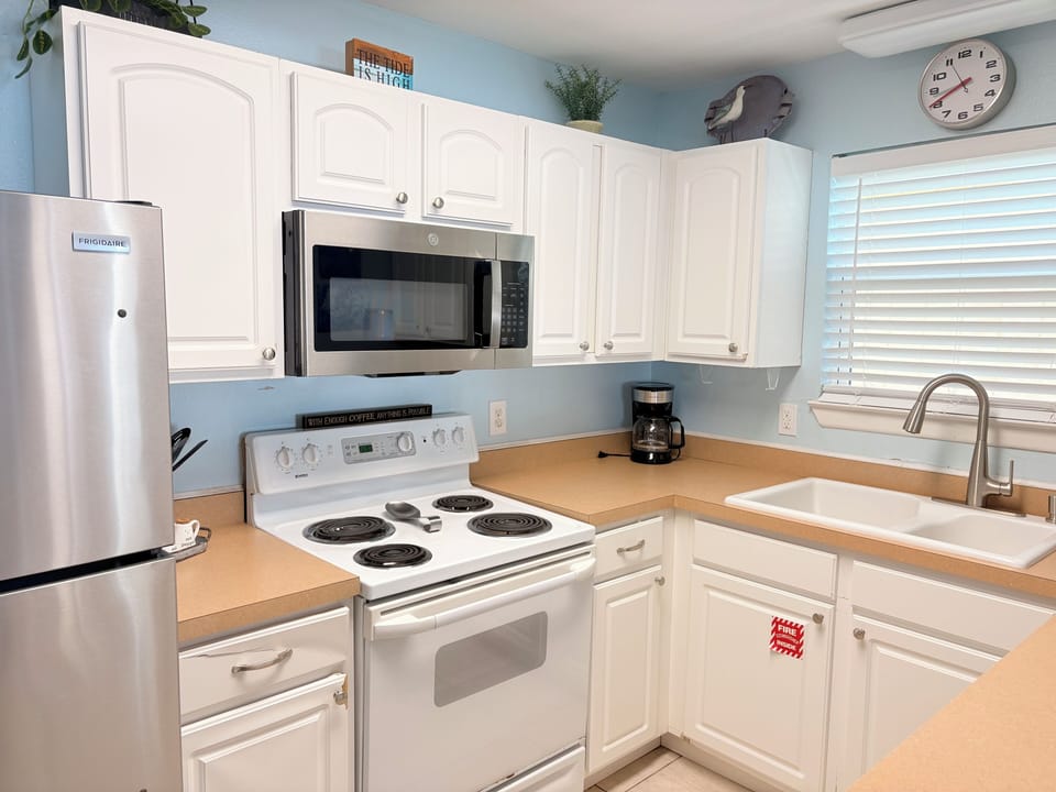 Your fully equipped kitchen features stainless steel appliances, crisp white cabinets, and ample counter space for preparing meals during your stay.