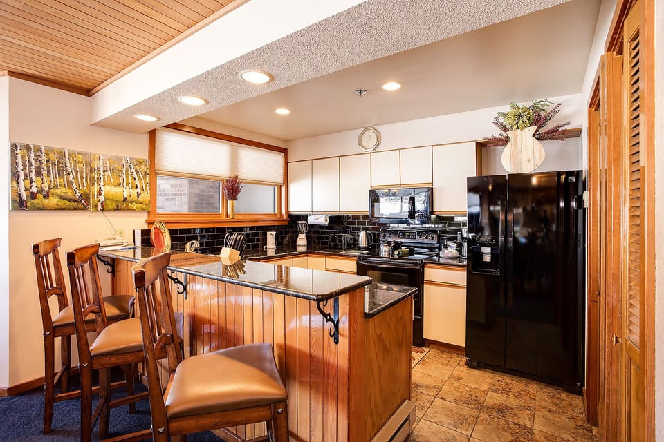 Cook your favorite meals in this fully equipped kitchen with granite countertops, modern appliances, and a breakfast bar where you can enjoy morning coffee.