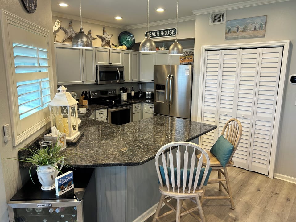 Your fully equipped kitchen awaits with granite countertops, stainless steel appliances, and charming coastal touches perfect for preparing meals together.