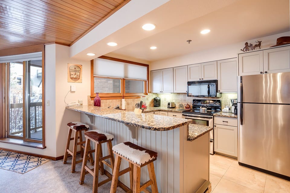 Cook your favorite meals in this spacious kitchen with granite counters, stainless appliances, and bar seating for casual dining together.