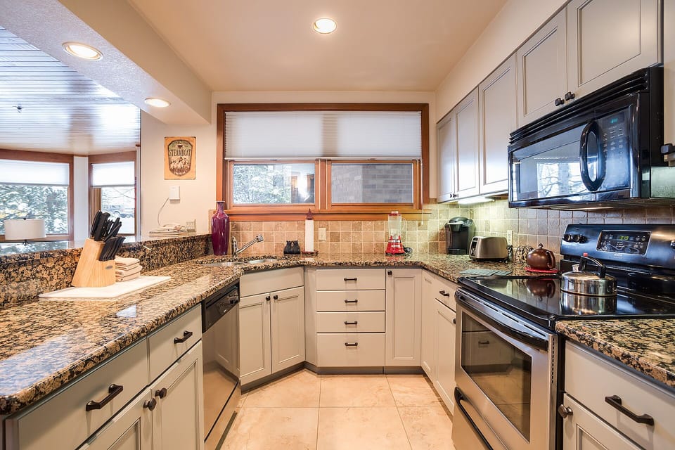 Your fully equipped kitchen features granite countertops, modern appliances, and warm lighting - perfect for preparing memorable meals during your stay.