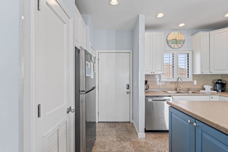 Your fully equipped kitchen features modern stainless steel appliances and elegant white cabinetry, perfect for preparing meals during your stay.