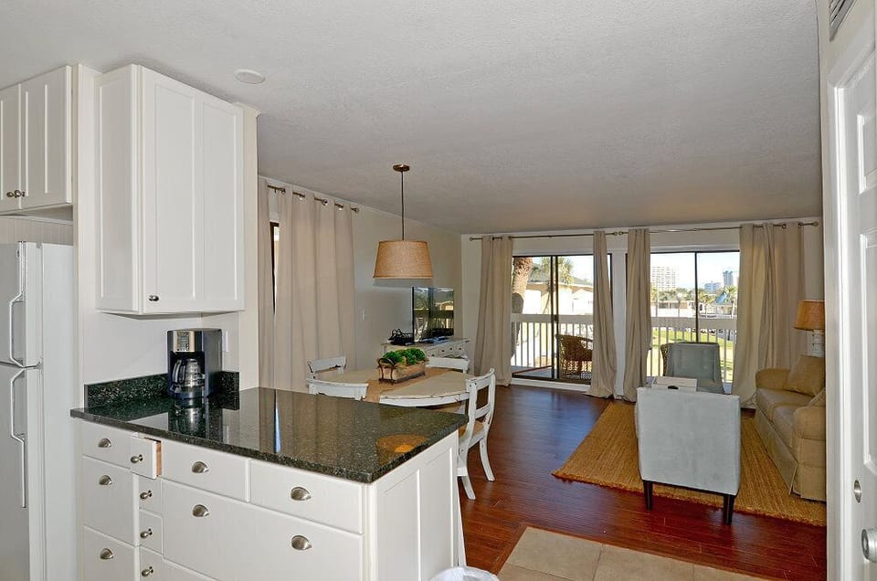 Step into your bright, open-concept kitchen and living space where warm hardwood floors guide you to panoramic windows showcasing stunning views.