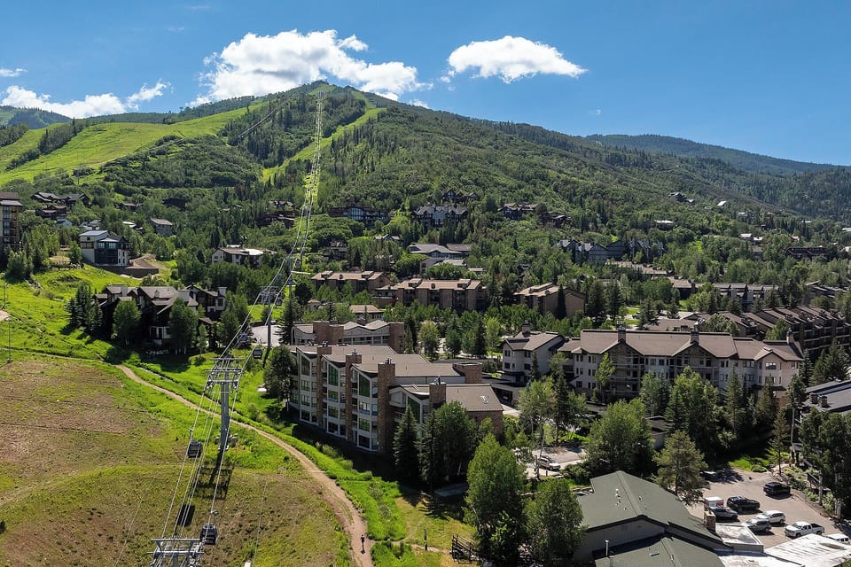 Mountain resort community nestled in lush green valleys with ski lifts and scenic alpine surroundings.