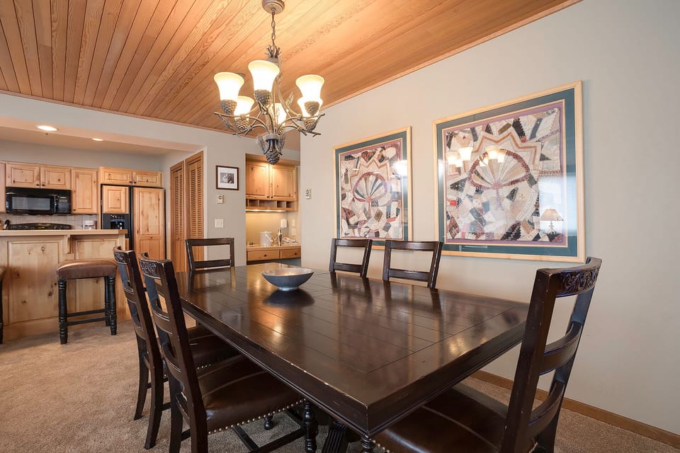 Gather around your elegant dining table beneath warm wood ceilings, where memorable meals and conversations unfold in this beautifully appointed space.
