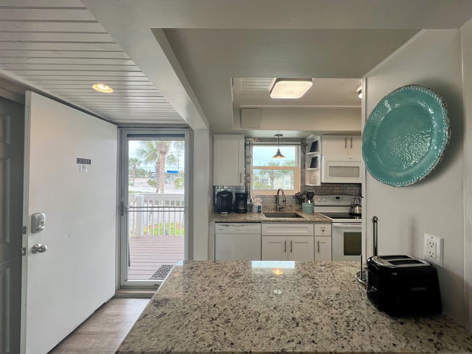 Your fully equipped kitchen with granite counters and modern appliances makes meal prep a breeze while you enjoy tropical views.