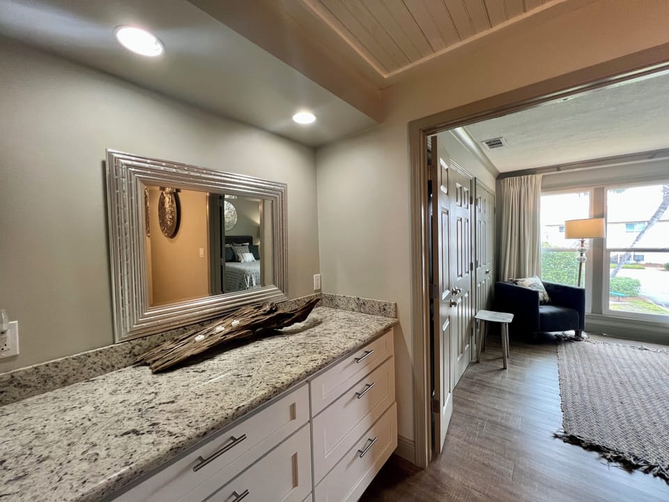Your elegant vanity area features granite countertops and stylish cabinetry, creating the perfect space for your morning routine.