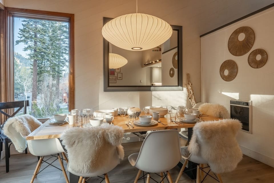 Your stylish dining space features cozy fur throws and warm pendant lighting, perfect for memorable meals with mountain views.