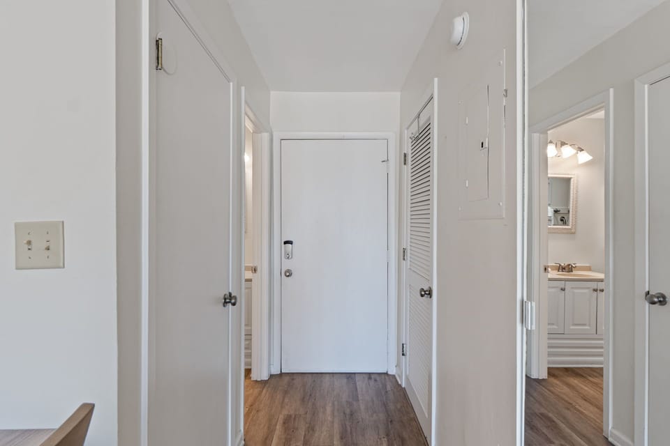 Step into your welcoming hallway with warm wood floors and bright white walls creating a fresh, airy feel throughout your space.