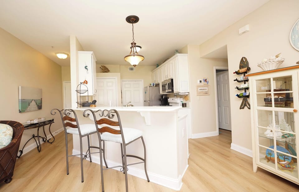 Gather around your kitchen island for morning coffee or evening conversations in this bright, open space with coastal charm.