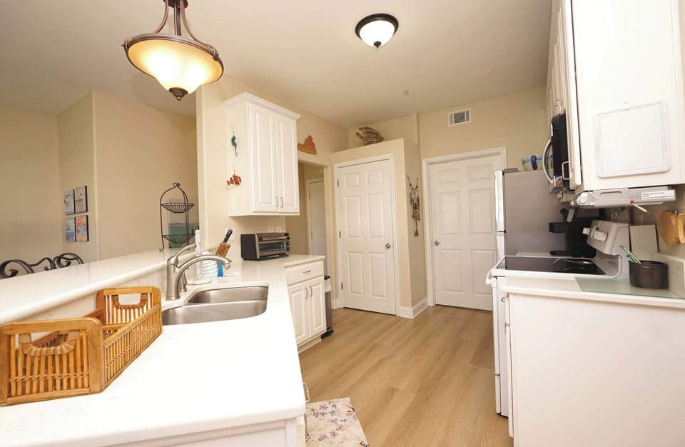 Cook comfortably in your fully equipped kitchen with white cabinetry, modern appliances, and plenty of counter space for meal prep.