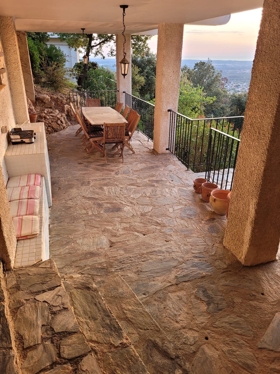Covered terrace downstairs with simple kitchen and large dining table