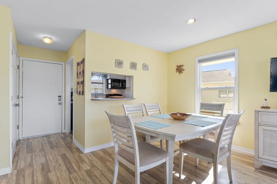 Gather around this bright dining space where sunlight streams through large windows, perfect for your morning coffee or memorable meals with loved ones during your stay.