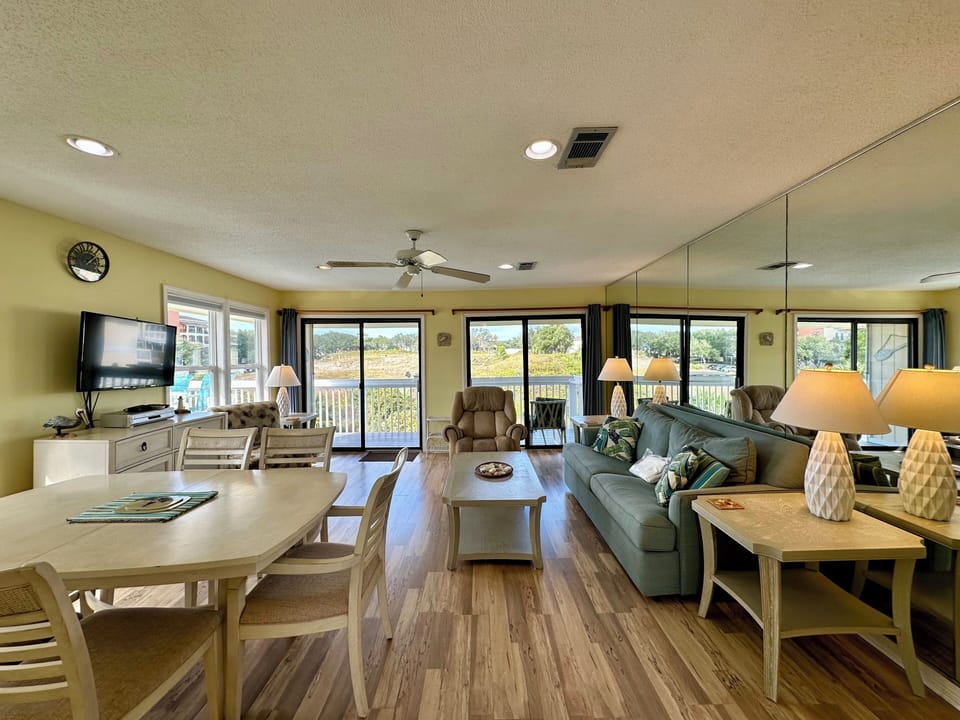 Relax in this bright, open living space with panoramic windows showcasing beautiful marsh views, perfect for peaceful mornings and cozy evenings.