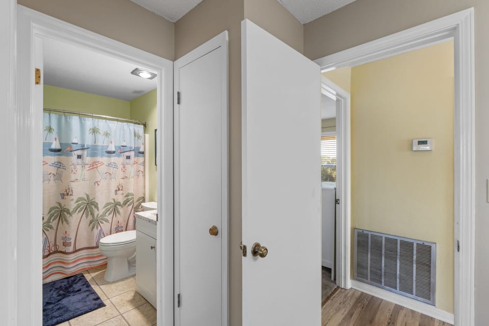 Step into your private retreat with clean hallways connecting vibrant spaces. A cheerful bathroom with beach-themed decor awaits, making your stay feel like a seaside getaway.