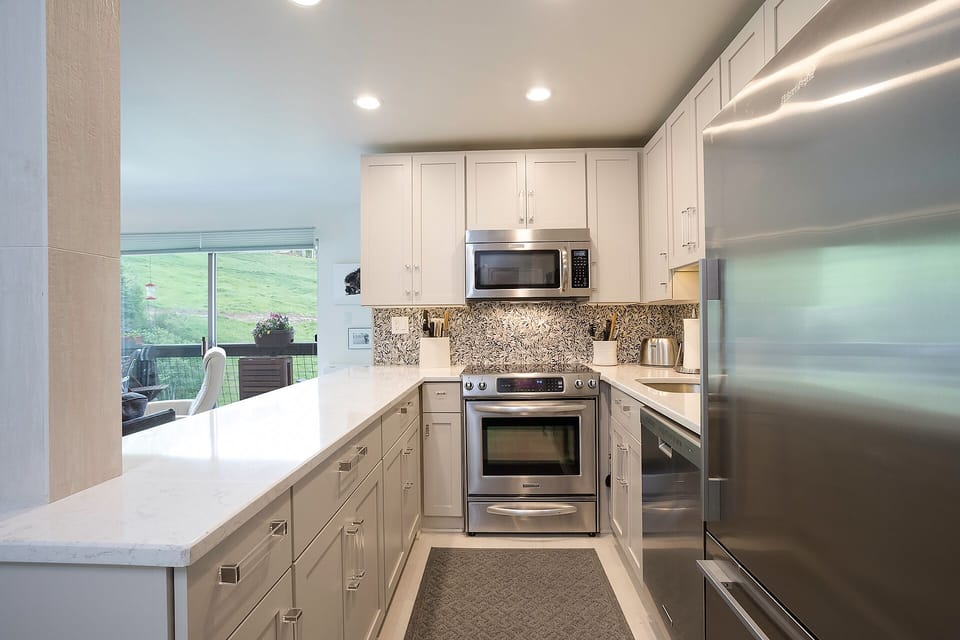 Your fully equipped kitchen features modern appliances and scenic views, perfect for preparing meals while enjoying the peaceful landscape outside.