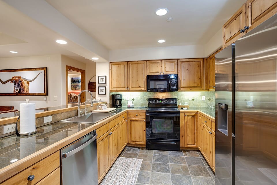 Your fully equipped kitchen features warm wood cabinets, granite counters, and stainless steel appliances for easy meal prep.
