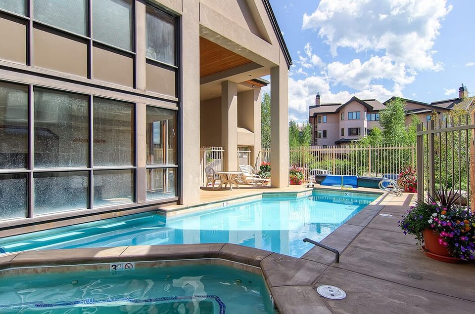 Dive into your private oasis with sparkling pool and soothing hot tub, surrounded by vibrant blooms and mountain views.