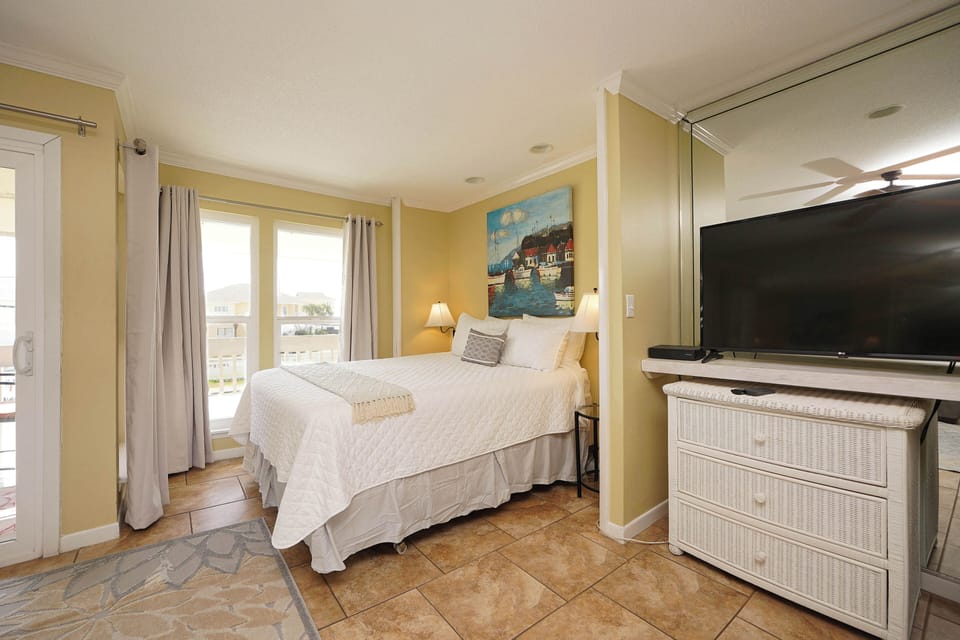 Wake up in this sunny bedroom with warm coastal colors and modern amenities, where soft natural light flows through your windows.