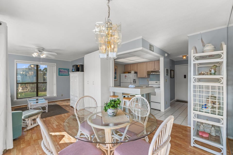 Gather around the elegant glass-top dining table, perfectly lit by a stunning chandelier, where your vacation meals become cherished memories. The open layout connects seamlessly to the fully equipped kitchen, making entertaining effortless.