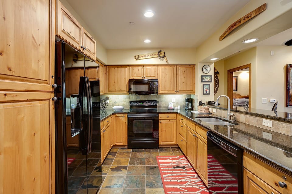 Your fully equipped kitchen with granite counters, modern appliances, and warm knotty pine cabinetry invites you to prepare fresh meals during your mountain getaway.